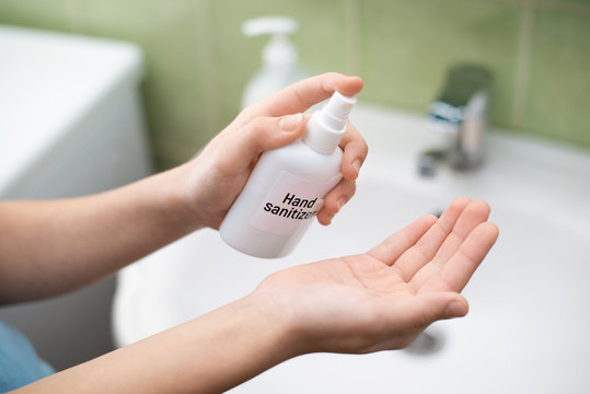 Schoolgirl sanitizing hands in bathroom. It is essential to keep hands clean during coronavirus pandemic