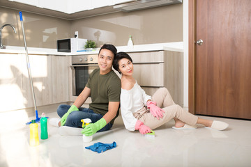 Young happy couple is having rest after doing cleaning at home.