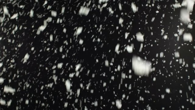 Snow falling on Black Background. The winter blizzard has snowflakes falling in the foreground. Stock Video Clip Footage