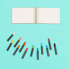 Flat lay with colored pastel crayons and open sketch pad for school, education. Set of colorful chalks. Design background social media.