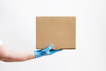 Delivery man holding a box on white background, delivery man in protective gloves