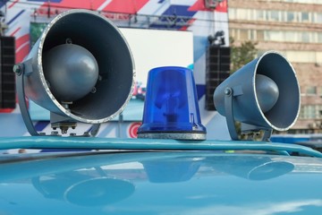 Details of retro police car with a megaphone and flashing blue siren light mounted on top. Loud-hailers on police car for message information at emergency. Vintage loudspeakers. © Matrix Reloaded