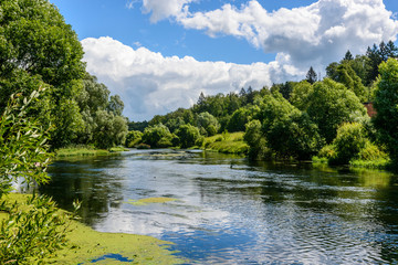 Blue sky with clouds reflected on the surface of river