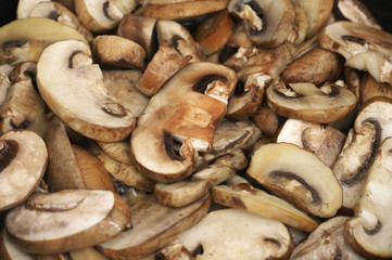 Chopped champignon mushrooms frying in pan
