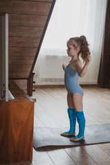 The girl does gymnastics at home. Gymnastics video tutorial. Gymnastic exercises. The idea for a children's activity in quarantine