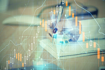 Multi exposure of hands making notes with forex chart huds. Stock market concept.
