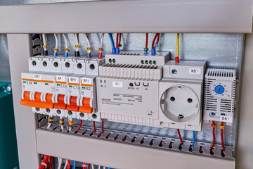 Circuit breakers, thermostat, power supply, socket in electrical Cabinet. The wires are connected to electrical equipment. Professional production, repair and maintenance.