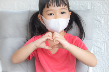ovid-19 virus and Air pollution pm2.5 concept.Little asian girl wearing mask for Virus and quarantined fight at home for stop corona virus outbreak.Covid19 and epidemic virus symptoms.