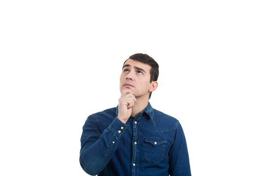 Portrait of unsure, perplexed man looking up and thinking for a solution. Thoughtful expression of a young man over white background.