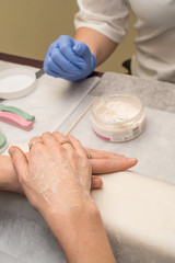 Obraz na płótnie Canvas Woman hands in a nail salon receiving a manicure. Nail filing. Close up
