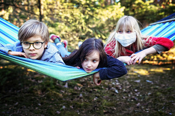 Fototapeta na wymiar friends on a hammock are playing during a coronavirus pandemic