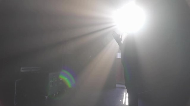man in a suite is praying in the light 