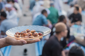 Close up of man hand holding date-palm in a disi at Ramadan iftar buffet festival