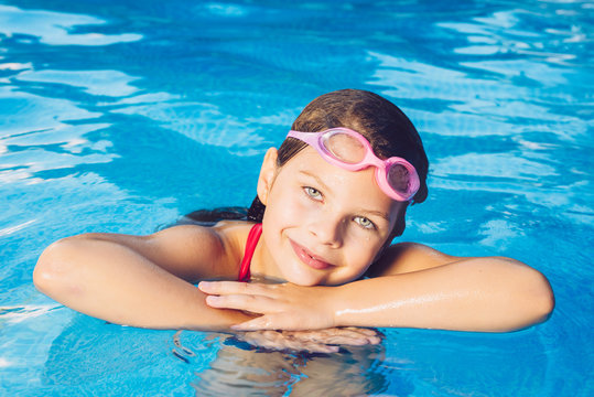 Portrait of a small smiling girl in a garden pool