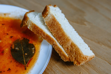 White bread, lying on a plate with something resembling soup