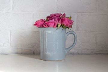 Blue cup with pink roses on the table
