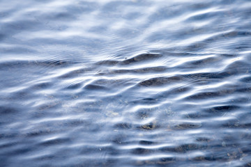 Flowing clean water surface waves and reflection pattern natural lake stream brook river ecology backround