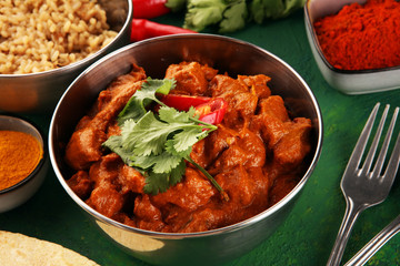 Chicken tikka masala spicy curry meat food in pot with rice and naan bread. indian food on table