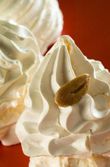 Meringhe guarnite alle mandorle su piatto rosso, macro