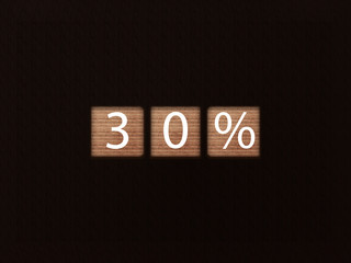 The inscription 30% sale on wooden blocks on black background. Letter text on wooden cube.