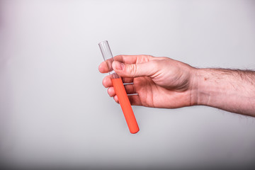 Hand holds a test tube containing a blood sample or other liquid, test tube with blood for Covid-19 (coronavirus) ncov analyzing. Laboratory testing patient’s blood. Copy space for text.