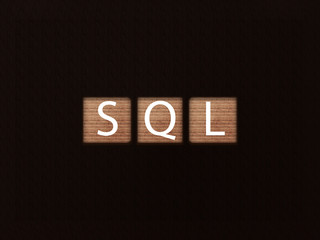 The inscription SQL language on wooden blocks on black background. Letter text on wooden cube.
