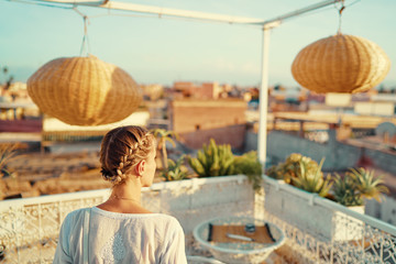 Young traveling woman enjoying the view of Marakech on roof top terrace.