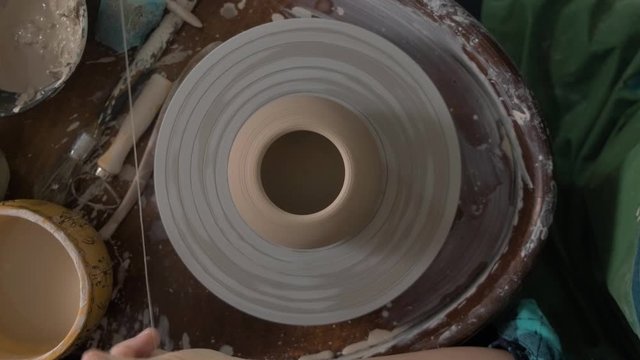 Potter special thread separates the clay vase from the Potter's wheel. The view from the top