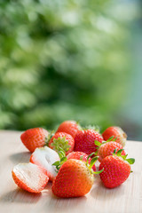 Fresh strawberries on the brown wooden table in garden, Red strawberry in farm on natural blur background