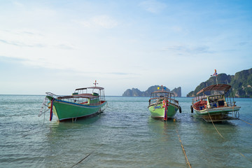 Naklejka premium Beautiful tropical landscape with traditional fishing longtail boats on the beach.