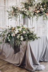 Stylish wedding floristics. Banquet tables decorated with arrangements of flowers, herbs and candles
