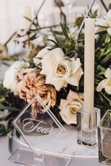 Stylish wedding floristics. Banquet tables decorated with arrangements of flowers, herbs and candles