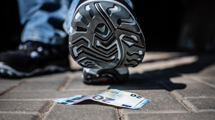 Schuhsohle Schuh von unten mit zwanzig Euro Geldschein Banknote Konkurs Inflation