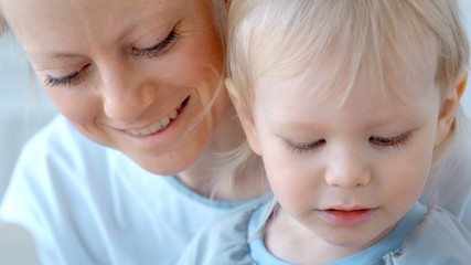 Concept during self-isolation and quarantine. A woman with a small child sews a protective mask.