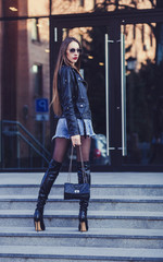 full-length portrait of a beautiful woman in a skirt and long leather boots