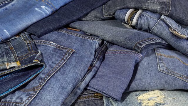 4K view of a pile of jeans clothes falling shirt