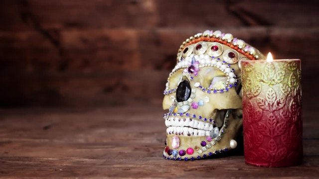 Screensaver for the film, movie, channel. Decorated with beads, rhinestones, stones, a human skull, a red candle with a yellow pattern. The candle itself lights up and goes out with smoke.