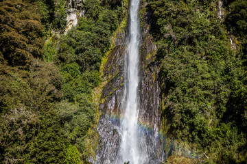 Obraz premium Cachoeira grande cercada por vegetação verde e arco iris