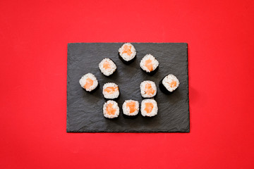 House shape sushi rolls on red background with copy space. Ordering sushi online at home while quarantine