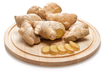 ginger and sliced root on wooden cutting board isolated on white background