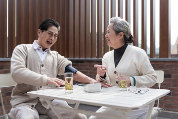 An Asian elderly couple is measuring blood pressure