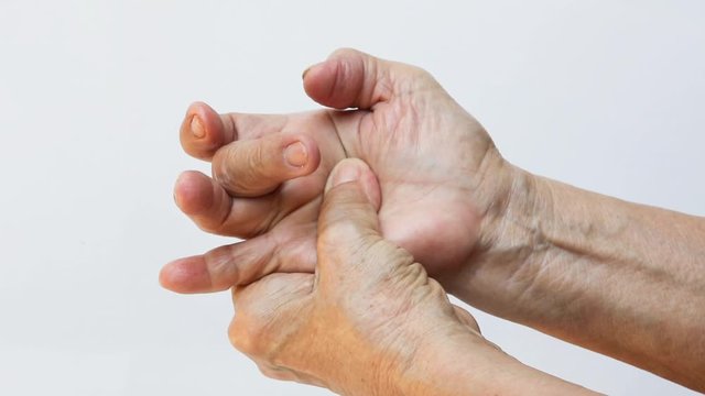 Trigger Finger lock on middle finger, Senior woman's right hand massaging her left hand Suffering from pain on white background, Close up shot, Office syndrome, Healthcare, Massage, Asian body concept