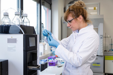 Scientist taking cbd samples from chromatography machine in laboratory