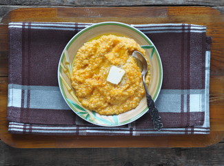 Millet porridge with pumpkin on wooden background. Healthy eating concept.