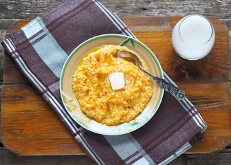 Millet porridge with pumpkin on wooden background. Healthy eating concept.