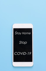 “Stay Home” text on mobile phone over blue background