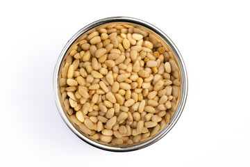 Pine Nuts in Stainless Steel bowl isolated on a white background, cooking ingredient and garnish. Closeup detail, delicious raw seed.