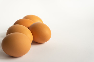 Five fresh brown chicken eggs in a row diagonally on grey background. Easter holiday