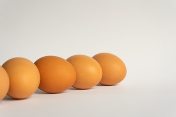 Five fresh brown chicken eggs in a row diagonally on grey background. Easter holiday
