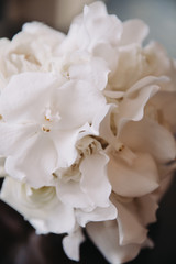 Fototapeta na wymiar Wedding floristry. Bouquet of white flowers with a white ribbon lies on a wooden table